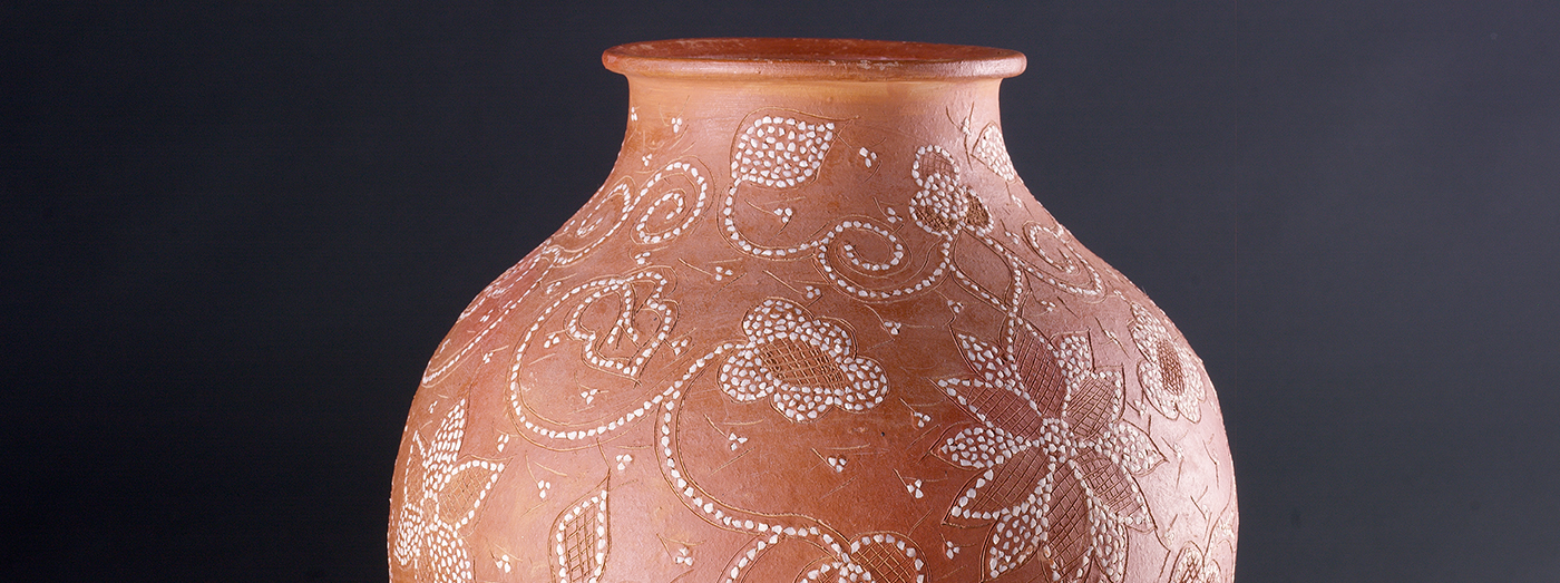 A operária introduz as pedrinhas de quartzo ao longo dos riscos feitos na peça, sempre com a parte mais pontiaguda para dentro e depois pressiona-as com a unha do polegar.
