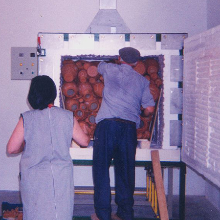 Processo de tingimento da peça com barro vermelho, utilizando a aplanata